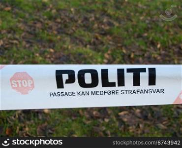 Danish police barrier sign. Politi, danish police barrier sign with meadow in background