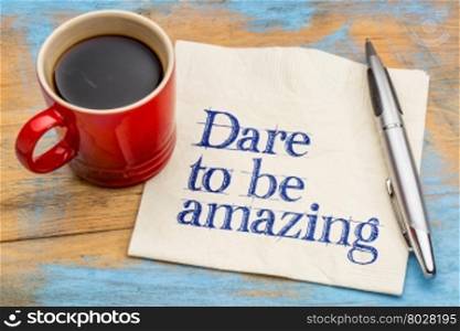 Dare to be amazing - motivational handwriting on a napkin with a cup of coffee