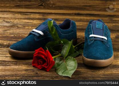 dark blue man&rsquo;s shoes and rose on wooden background