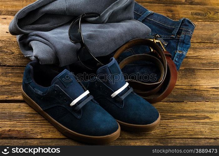 dark blue men&rsquo;s shoes, jeans, pullover hoodie sweatshirt and accessories on wooden background