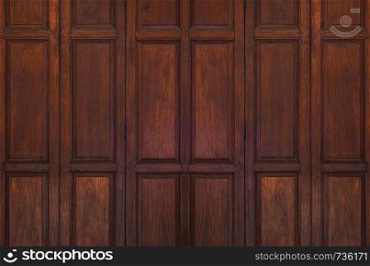 Dark brown old ancient wooden swing door background. Thailand traditional style. Using as wall or wallpaper.