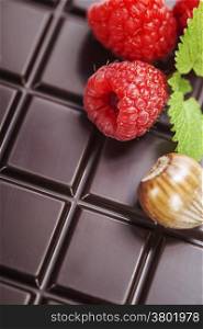 dark chocolate bar with raspberry as background