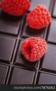 dark chocolate bar with raspberry as background