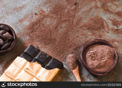 dark chocolate bar with scattered cocoa powder beans bowl rustic backdrop