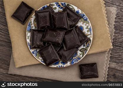 Dark Chocolate bars on napkins and brown wooden background