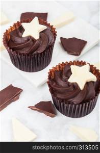 Dark chocolate cupcakes with white chocolate star on marble board