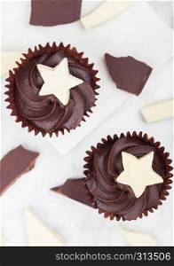 Dark chocolate cupcakes with white chocolate star on marble board