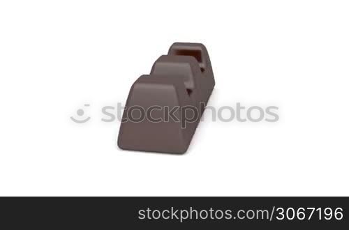 Dark chocolate filled with caramel rotates on white background