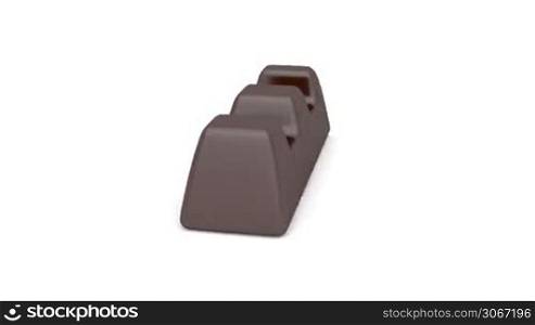 Dark chocolate filled with caramel rotates on white background