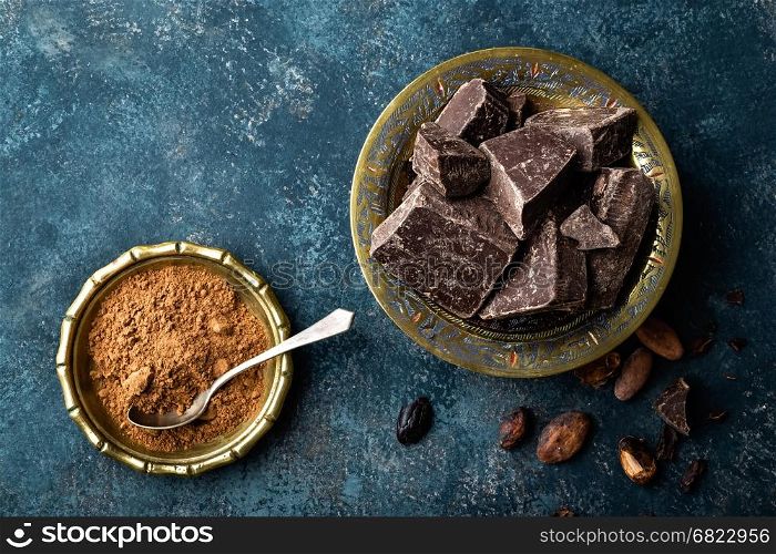 Dark chocolate pieces crushed and cocoa beans, culinary background, directly above