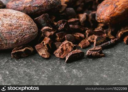 Dark chocolate pieces crushed and cocoa beans, top view