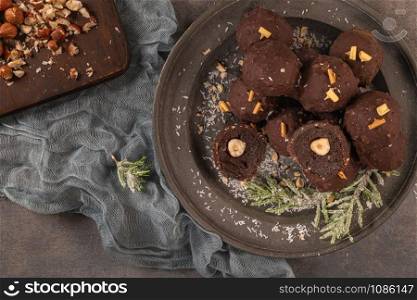 Dark chocolate truffles with hazelnuts on plate. Top view. Flat lay