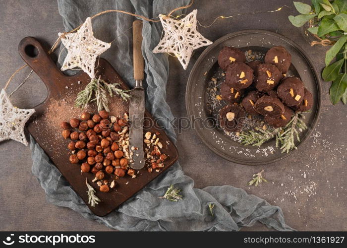 Dark chocolate truffles with hazelnuts on plate. Top view. Flat lay