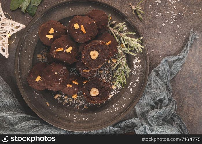 Dark chocolate truffles with hazelnuts on plate. Top view. Flat lay