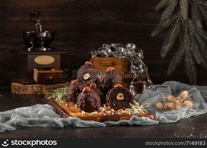 Dark chocolate truffles with hazelnuts over wooden cutting board.