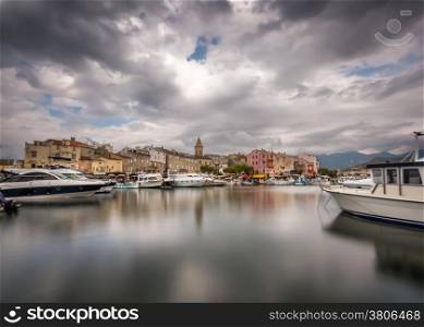 Dark clouds over the boats and harbour of Saint Florent in northern Corsica