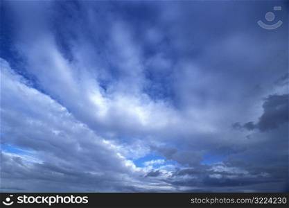 Dark Clouds Streaking Through A Blue Sky
