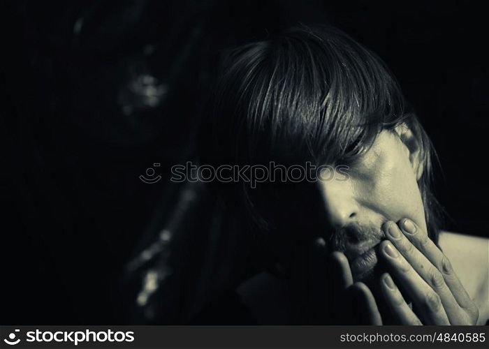 Dark contrast portrait of a young depressed man