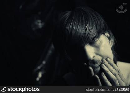 Dark contrast portrait of a young depressed man