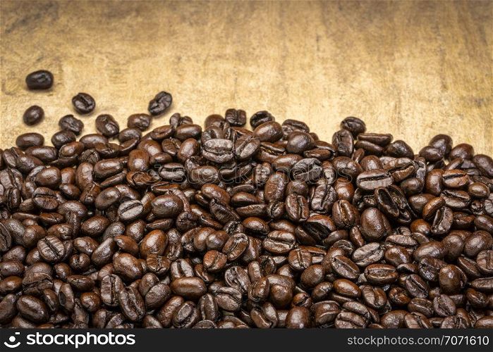 dark French roast coffee beans against textured bark paper
