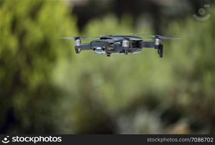dark grey drone flying over a green background