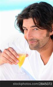 Dark haired man drinking orange juice