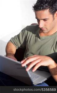 Dark haired man sat with laptop