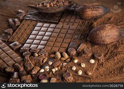 Dark homemade chocolate bars and cocoa pod on wooden . Chocolate bar, candy sweet, cacao beans and powder on wooden background