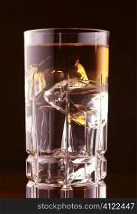 Dark liquid with ice in glass