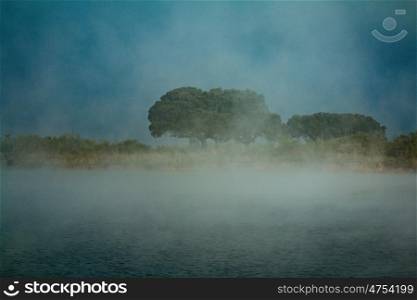 Dark morning on a river with many fog over the water
