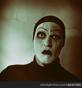 Dark portrait of actor with mime makeup on her face