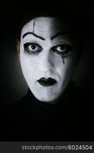 Dark portrait of actor with mime makeup on her face