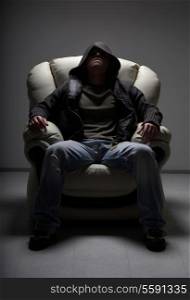 dark portrait of dangerous man sitting in white chair