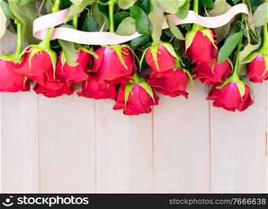 dark red fresh roses laying on wooden table, with copy space. dark red roses on table