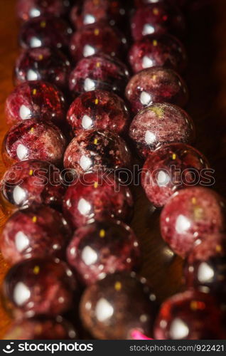 Dark red garnet, natural stone beads, january birthstone macro background.