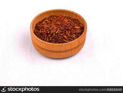 Dark rice in a wooden cup on a white dining table
