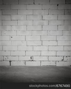 Dark room with cement floor and block wall background