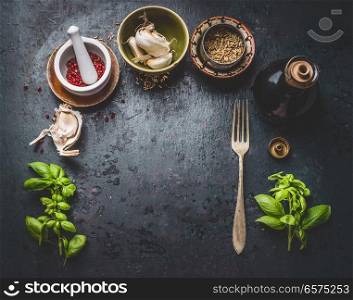 Dark rustic aged food background with  fork, bowls of herbs, spices and seasoning, top view with copy space for your design,recipes,menu, meal or text, frame