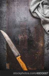 Dark rustic food background with kitchen knife and napkin, top view