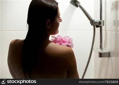 Dark silhouette of sexy woman washing in shower