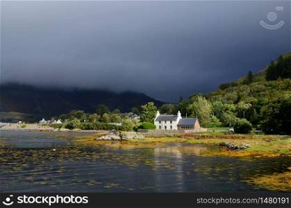 Dark skies in Kyle of Lochalsh with a cute house on the shore