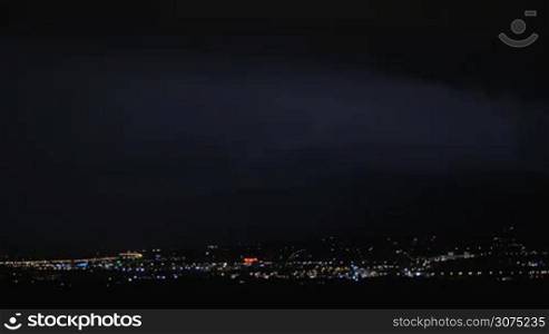 Dark sky flashing with lightnings during the night storm over the city