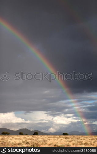 Dark sky with clouds and a rainbow