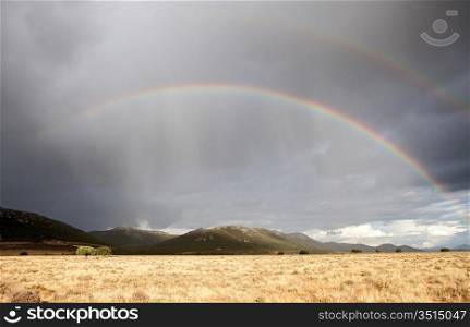 Dark sky with clouds and a rainbow