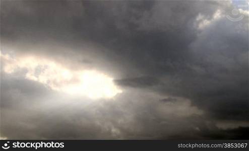 Dark stormy clouds forming at sunset.Time warp or time lapse accelerated.Give an ominous feel to your project.Awesome black storm clouds with sun rays crossing.