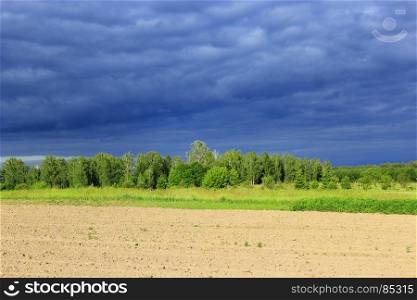 dark thundercloud clouds under the forest and land. landscape with dark thundercloud clouds under the forest and land