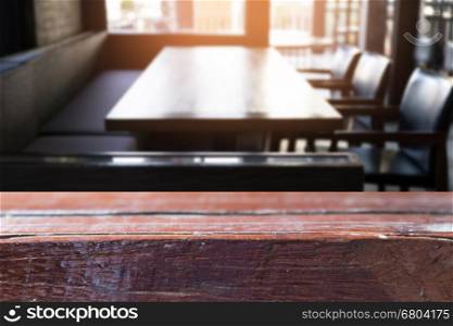 dark tone of cafe restaurant interior blur background with selected focus empty wood table for display or montage your product