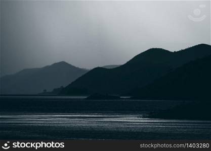 dark tone of mountain layers with lake tropical forest