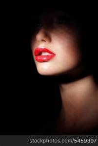 Darkness. Woman&#39;s Face with Sexy Red Lips in Spotlight and Shadows. Secrecy