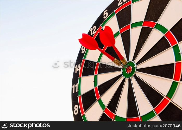 Dart arrow hitting to center on bullseye (bull&rsquo;s-eye) dartboard is the target of purpose challenge business at sunset, expert marketing strategy target, objective financial and goal success